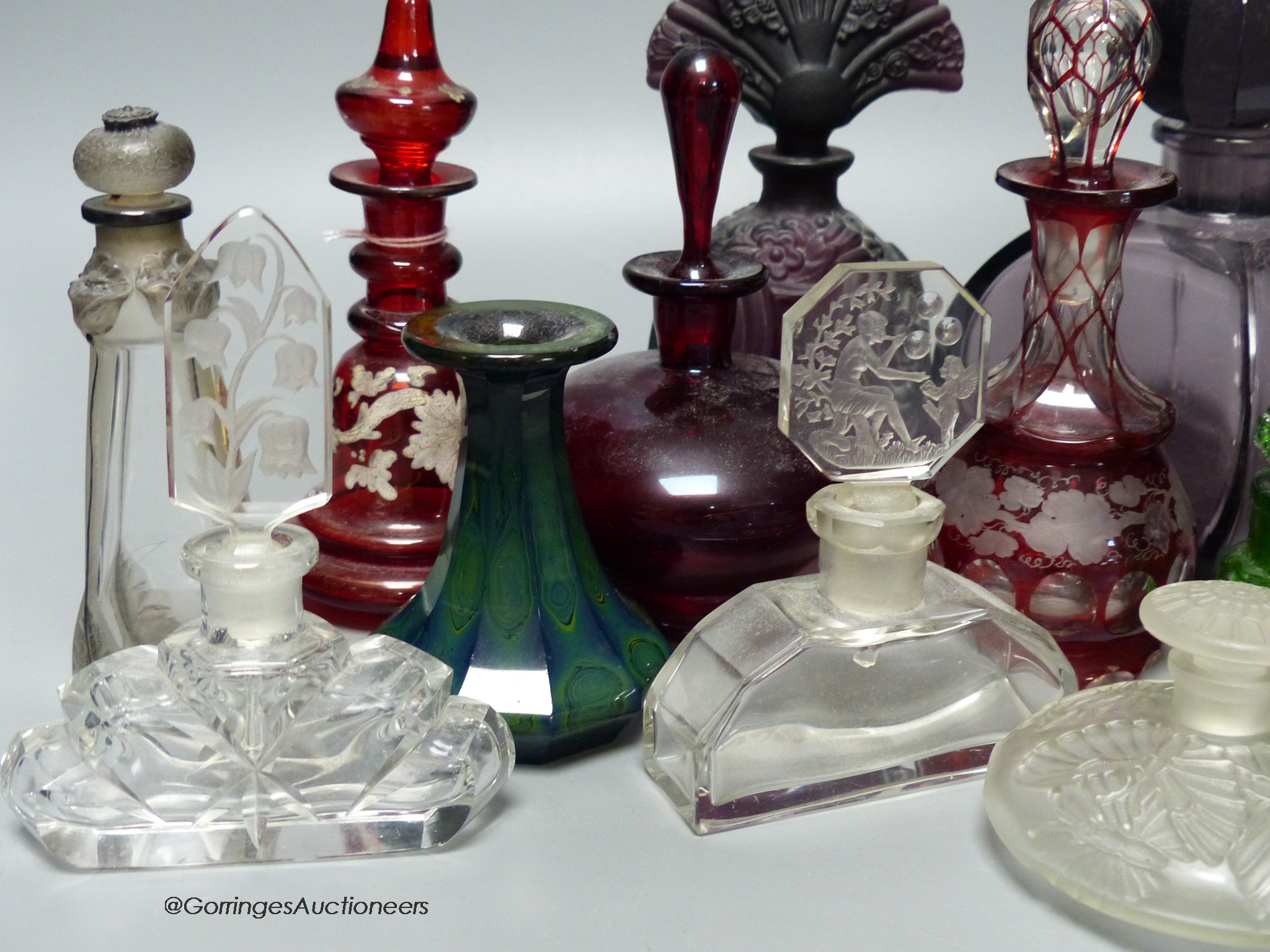 A collection of 1920's and earlier glass scent bottles to include ruby, amethyst, blue, clear and green